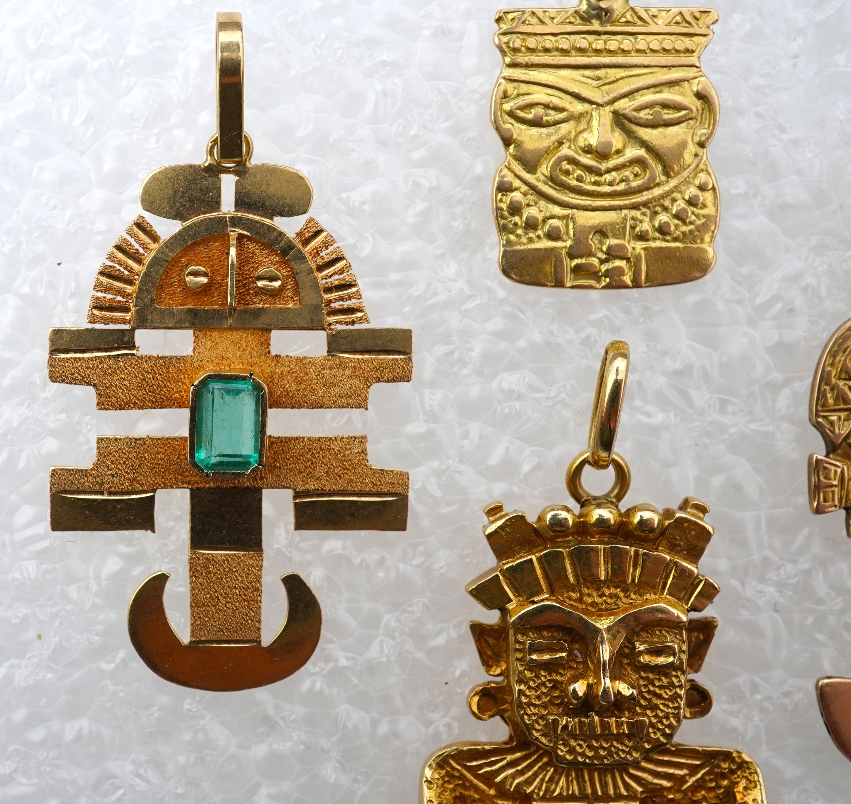 A collection of five gold pendants